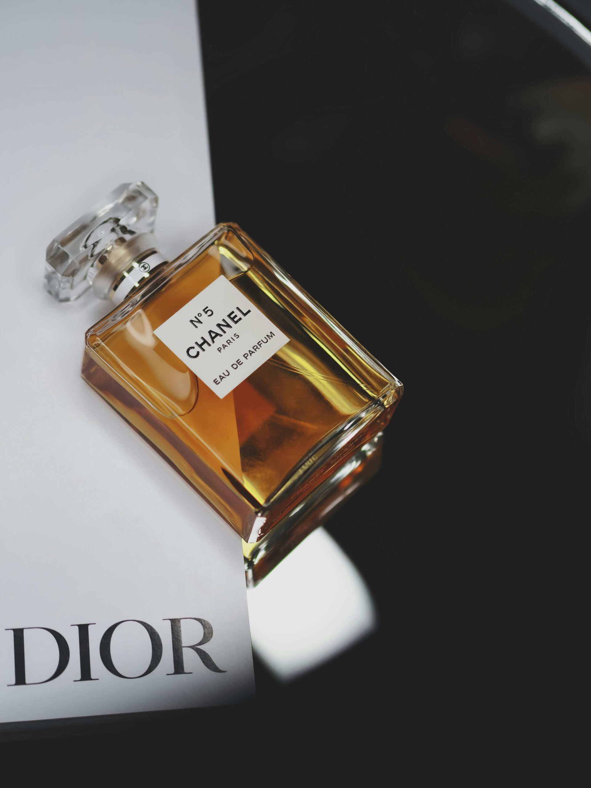 Chanel No. 5 perfume bottle elegantly styled on a Dior surface.
