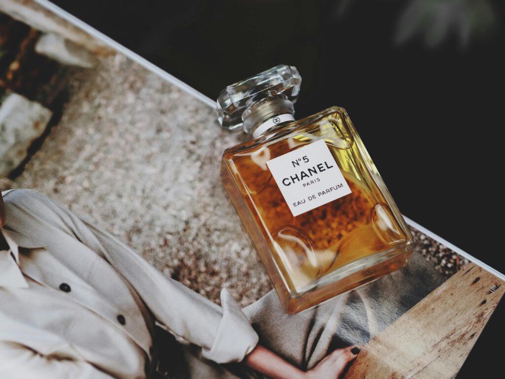 Chanel No. 5 perfume bottle elegantly resting on a magazine, showcasing luxury and style.